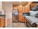 Kitchen featuring stainless steel appliances, oak cabinets, and stone tile floors at 22834 E Davies Dr, Aurora, CO 80016