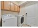 Bright laundry room featuring washer, dryer, and cabinets at 22834 E Davies Dr, Aurora, CO 80016
