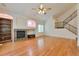 Living room featuring hardwood floors, vaulted ceilings, a fireplace, and stairs to the second floor at 22834 E Davies Dr, Aurora, CO 80016