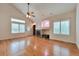 Living room featuring hardwood floors, vaulted ceilings, a fireplace, and many windows providing plenty of natural light at 22834 E Davies Dr, Aurora, CO 80016
