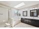 Bright bathroom with a separate shower and tub, dual sinks, and a skylight at 9823 Salford Ln, Highlands Ranch, CO 80126