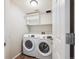 Laundry room with a washer, dryer, shelving, and wood-look flooring at 9823 Salford Ln, Highlands Ranch, CO 80126