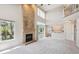 Spacious living room features a brick fireplace, large windows, and a view to the backyard patio at 9823 Salford Ln, Highlands Ranch, CO 80126