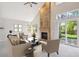 Staged living room with brick fireplace, seating, and view of the backyard at 9823 Salford Ln, Highlands Ranch, CO 80126