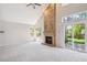 Bright living room with a brick fireplace, large windows, and sliding door to backyard at 9823 Salford Ln, Highlands Ranch, CO 80126
