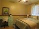 Cozy bedroom with warm yellow walls, wooden floors, and a decorative desk under a window at 17671 E Brown Cir, Aurora, CO 80013
