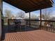 Covered deck with overhead string lights, round table with seating and a brown stained wood floor at 17671 E Brown Cir, Aurora, CO 80013