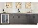 Entertaining bar area featuring dark wood cabinets, a wine fridge, and a marble countertop at 8873 Princeton St, Westminster, CO 80031