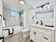 Well-lit bathroom with a sleek white vanity, marble-style tiling, and modern black fixtures at 8873 Princeton St, Westminster, CO 80031