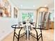 Bright dining area features a dining table, wood floors, modern stainless steel refrigerator, and backyard views at 8873 Princeton St, Westminster, CO 80031