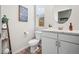 Bright half-bathroom features wood-look floors, white vanity, and modern fixtures at 5148 Taft Ct, Wheat Ridge, CO 80033