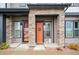 Inviting front entrance features a decorative wreath, stylish orange door, and charming stone accents at 5148 Taft Ct, Wheat Ridge, CO 80033