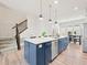 Spacious kitchen with a large blue island featuring a sink, dishwasher, and bar seating at 5148 Taft Ct, Wheat Ridge, CO 80033