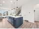 Open concept kitchen features a large, navy blue island with a white countertop and modern pendant lighting at 5148 Taft Ct, Wheat Ridge, CO 80033