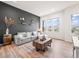 Bright living room featuring a comfortable gray sofa, wood floors, and a large window at 5148 Taft Ct, Wheat Ridge, CO 80033