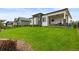 Large backyard with lush green lawn, modern exterior, and covered patio at 2794 Heron Lakes Pkwy, Berthoud, CO 80513