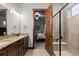 Bright bathroom featuring double vanity with granite countertop and glass shower with a seat at 2794 Heron Lakes Pkwy, Berthoud, CO 80513