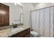 Bathroom featuring a vanity with a granite countertop, large mirror, and tub with geometric curtain at 2794 Heron Lakes Pkwy, Berthoud, CO 80513