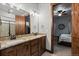 Bright bathroom with double vanity with granite countertop and mirrors reflecting the shower and bedroom at 2794 Heron Lakes Pkwy, Berthoud, CO 80513