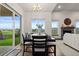 Bright dining room with sliding glass doors, wood table and decorative chandelier at 2794 Heron Lakes Pkwy, Berthoud, CO 80513