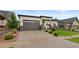Exterior elevation showcasing a well-maintained lawn and a three-car garage with a large driveway at 2794 Heron Lakes Pkwy, Berthoud, CO 80513