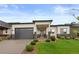 Attractive single-story home with dark garage door, stone accents and manicured front lawn at 2794 Heron Lakes Pkwy, Berthoud, CO 80513