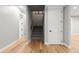 Hallway with hardwood floors leading to a staircase and a closed door at 2794 Heron Lakes Pkwy, Berthoud, CO 80513