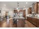 Spacious kitchen featuring granite countertops, a center island with seating, and elegant wooden cabinetry at 2794 Heron Lakes Pkwy, Berthoud, CO 80513
