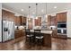Kitchen features wooden cabinetry, stainless steel appliances, granite countertops, and an island with bar seating at 2794 Heron Lakes Pkwy, Berthoud, CO 80513