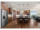 Kitchen boasts stainless steel appliances, wooden cabinetry, a central island with bar seating, and modern lighting fixtures at 2794 Heron Lakes Pkwy, Berthoud, CO 80513