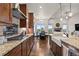 Open kitchen with granite countertops, modern appliances, and a view into the adjacent living and dining areas at 2794 Heron Lakes Pkwy, Berthoud, CO 80513