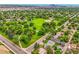 A lush green park surrounded by trees and houses in an aerial view featuring the Denver skyline at 5152 Bryant St, Denver, CO 80221