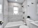 Beautiful bathroom features modern tile, a shower-tub combo, and a built-in toiletries nook at 5152 Bryant St, Denver, CO 80221