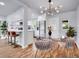 Stylish dining area with a glass table, plush chairs, and modern chandelier next to the kitchen at 5152 Bryant St, Denver, CO 80221
