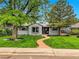 Charming single-story home with well-maintained lawn, mature trees, and a welcoming walkway at 5152 Bryant St, Denver, CO 80221