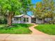 Charming single-story home with mature trees, manicured lawn, and a welcoming walkway at 5152 Bryant St, Denver, CO 80221