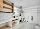 Bright laundry room features open shelving, a utility sink, and space for a washer and dryer at 5152 Bryant St, Denver, CO 80221