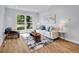 Inviting living room with hardwood floors, large windows, and comfortable, stylish furniture at 5152 Bryant St, Denver, CO 80221