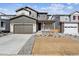 Charming two-story home with a front porch, gray siding, a well-manicured lawn, and an attached two-car garage at 1397 Brookfield Pl, Erie, CO 80026