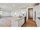 Modern kitchen island features white cabinets, stainless steel appliances, and hardwood-style floors with ample natural light at 1397 Brookfield Pl, Erie, CO 80026