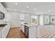 Modern kitchen island features white cabinets, stainless steel appliances, and a view of the sliding glass door at 1397 Brookfield Pl, Erie, CO 80026