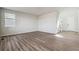 Bright and airy living room with hardwood-style floors, white walls, base trim, and natural light from the exterior windows at 1397 Brookfield Pl, Erie, CO 80026