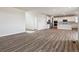 Open-concept living room and kitchen with hardwood-style floors and bright white paint at 1397 Brookfield Pl, Erie, CO 80026