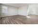 Unfurnished living room with hardwood floors, large window, and staircase access at 1397 Brookfield Pl, Erie, CO 80026