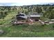 Aerial view of a multi-level mountain home with decks, a small yard, and a parked SUV at 393 Dixon Rd, Boulder, CO 80302
