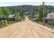 Scenic view of a rustic dirt road lined with charming log cabins and mountain landscape at 393 Dixon Rd, Boulder, CO 80302