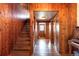Inviting hallway with wood-paneled walls, staircase, and hardwood flooring, radiating warmth and character at 393 Dixon Rd, Boulder, CO 80302