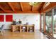 Open living area with wood beam ceiling, entertainment console, and walkout to the deck at 393 Dixon Rd, Boulder, CO 80302