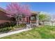 Inviting covered front porch with a red door, decorative wreath, and pretty landscaping at 13668 Plaster Cir, Broomfield, CO 80023