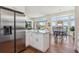Open kitchen with a large island, stainless steel refrigerator, and an adjacent dining area at 13668 Plaster Cir, Broomfield, CO 80023